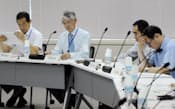 原子力規制委員会の評価会合で評価書案を見る委員ら(24日午前、東京都港区)