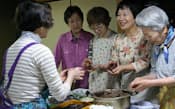 「玉ねぎツアー」のために友人とぼた餅作りに精を出す露木サヨ子さん(右から2人目)