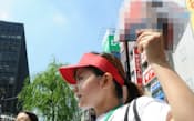 暑さ対策のためサンバイザーを着けてビラを配る選挙スタッフ(9日午前、東京・新橋)