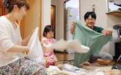 帰宅後、家族で洗濯物をたたむサントリーウエルネスの白滝さん夫妻(東京都日野市)