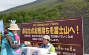 富士山入山料の徴収が始まり、「富士山保全協力金」を支払う登山者（25日午前、富士宮口5合目）