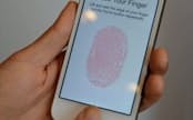 アップルが発表した「iPhone5S」。指を乗せて指紋登録し、個人認証する(10日、米カリフォルニア州の本社)