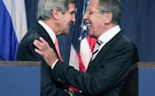 シリアの化学兵器放棄の枠組みで合意し、記者会見後に握手する米国のケリー国務長官(左)とロシアのラブロフ外相(14日、ジュネーブ)