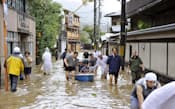 台風18号による大雨で道路が冠水し、ボートで救助される旅館の宿泊客ら（16日午前9時48分、京都市西京区）=共同