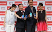 新型スマートフォンを手に記念写真に納まるNTTドコモの加藤社長(左から2人目)ら(10日午後、東京都港区)