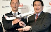 模型を手に記念写真に納まる日本航空の植木義晴社長(右)とエアバス社のファブリス・ブレジエ社長兼CEO（7日午後、東京都港区）=共同