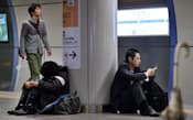 台風26号の影響で線路が冠水した小田急線の下北沢駅のホームに座り込む人たち（16日午前、東京都世田谷区）