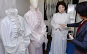 フューネラルドレスを試着する女性=左。夫向けに男性用の衣装を注文するケースも目立つ（東京都新宿区の「ファイナル・クチュール」）