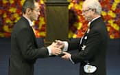 ノーベル賞授賞式で、スウェーデンのカール16世グスタフ国王(右)から生理学・医学賞のメダルと賞状を授与された山中伸弥京都大学教授（2012年12月10日、ストックホルムのコンサートホール）=共同