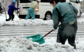 雪で立ち往生した車を押す人たちの姿も(15日午前、東京・銀座)