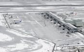 雪に覆われた羽田空港。欠航が相次ぎ、人や物の輸送に大きな影響が出た（15日）=共同