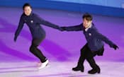 フィギュアスケートのエキシビション練習で、高橋大輔(右)と手をつないで滑走する浅田真央（21日、ソチ）=共同