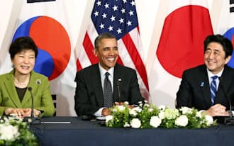 日米韓3カ国首脳会談で笑顔を見せる(右から)安倍首相、オバマ米大統領、韓国の朴槿恵大統領（25日  、オランダ・ハーグ）=共同