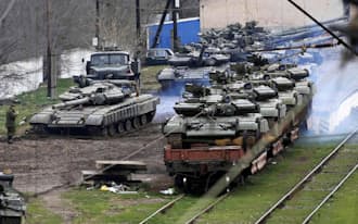 クリミア半島でウクライナ軍の戦車を誘導するロシア兵（27日）=ロイター