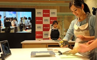 NTTドコモとABCクッキングスタジオが協力して実施した東京と香港をネットで結ぶライブ料理教室(中央奥が講師)