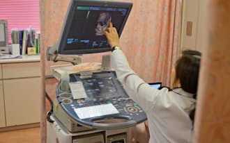 健診で訪れた妊婦に胎児のエコー映像を示す井上医師(東京都立川市の井上レディースクリニック)