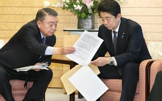 3月7日、自民党の大島東日本大震災復興加速化本部長（左）は「東日本大震災から3年を迎えるにあたっての決意」を安倍首相に手渡した