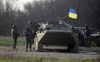 15日、ウクライナ東部の検問所を警備するウクライナ軍兵士=ロイター