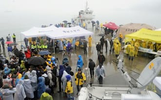 18日、旅客船沈没事故から3日目を迎えた韓国・珍島の漁港に集まった関係者ら=共同