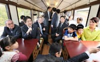 三陸鉄道北リアス線の車内で乗客と懇談する安倍首相(27日、岩手県)=代表撮影