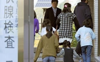 保護者に伴われ甲状腺の超音波検査に向かう子どもたち（2011年10月9日、福島市の県立医大病院）