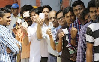 投票所で選挙IDを見せる有権者(5月12日、インド・バラナシ)