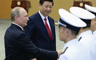 中ロ海軍による合同軍事演習の開始式に出席したロシアのプーチン大統領(左手前)と中国の習近平国家主席（20日、上海）=共同
