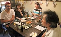 農家の吉岡龍一さん(左)の手料理を食べながら会話が弾む(YOL Cafe Frosch)