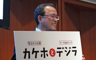 音声定額を柱とする携帯電話の新料金プランを発表する、KDDIの田中社長(25日、東京・千代田)