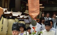 神職が掲げる神剣。明治までは実物の七支刀を木枠に納め、金錦の袋をかぶせていた(6月30日、奈良県天理市)