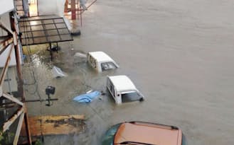 高知市内を流れる鏡川の増水で水没した車（10日午前5時46分）=共同