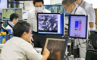 台風11号が近づくなか、予報官らは現業室で台風の進路などを検討していた(8日、気象庁)
