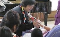「こころふれあいコンサート」で患者の子供の手を握る指揮者の大野和士氏（8月7日、横浜市の神奈川県立こども医療センター）=撮影　写真部　沢井慎也