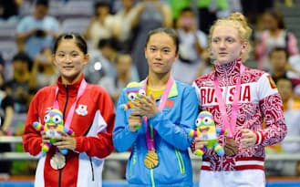 トランポリン女子で銀メダルを獲得し、表彰台で笑顔を見せる中野蘭菜=左（21日、南京）=新華社・共同