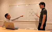 ヴォーカーズの増井慎二郎社長(左)に技術動向を説明する、技術責任者の榊亨氏