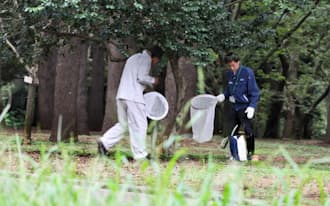 代々木公園で蚊を採集する国立感染症研究所の職員ら(4日午後、東京都渋谷区)