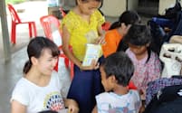 ボランティアプラットフォームのスタッフとしてカンボジアで子どもたちとふれあう諸星さん(左)