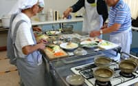 初めての料理に苦戦する男性シニアたち(大阪府吹田市で開かれた「超初心者向け男の料理教室」)