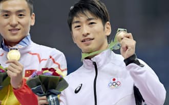 トランポリン男子で3位に入り、銅メダルを手に笑顔の上山容弘（26日、仁川）=共同