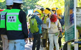 御嶽山の噴火から一夜明け、約20人の登山者や従業員らが岐阜県下呂市の濁河温泉近くの登山口に到着した（28日）
