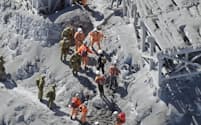 御嶽山の山頂付近の山小屋で救助活動する消防と自衛隊員（28日午前）=共同