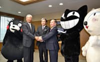 ヤマト運輸は熊本県と肥後銀行との間で、農水産物輸出に関する連携協定を結んだ。締結後、握手する熊本県の蒲島知事(中央)ら(21日)