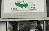 街頭テレビに映し出された大気中の放射線量（9日午後、東京都新宿区）=写真　橋本純