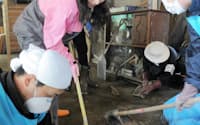 民家の倉庫にたまった泥をかき出す、県外からきたボランティア（3日、宮城県七ケ浜町）=写真　松本勇