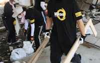 被災した旅館の片付けをするニコングループの社員ら（6日、宮城県石巻市）