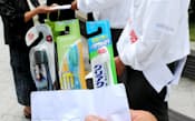 通行人に歯ブラシを配る歯ブラシメーカーの経営者ら（4日、大阪府八尾市）