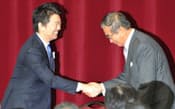 日本維新の会の全体会合で握手する石原代表（右）と橋下代表代行（17日、大阪市住之江区）