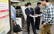 中国からの入国者に注意喚起のチラシを配る検疫所の職員（19日、成田空港）