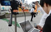 候補者の街頭演説をネット中継する選挙事務所のスタッフ（4日、東京都新宿区）
