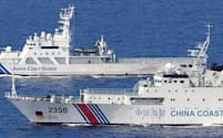 2013年に沖縄県・尖閣諸島の南小島南東の領海内に侵入した中国船（手前）。奥は日本の海上保安庁の巡視船=共同